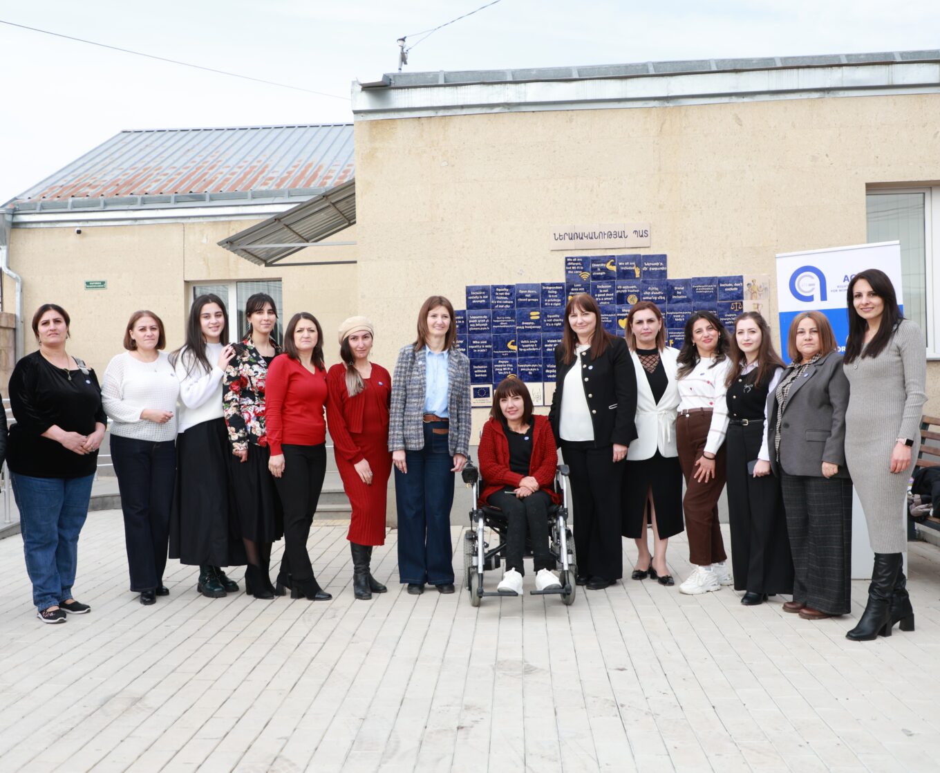 Ագաթ ՀԿ աշխատակազմն է կազմակերպության բակում՝ ներառականության պատի մոտ կանգնած