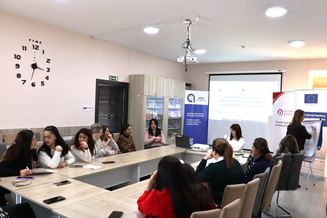 լուսանկարում դասընթացավարն է և սեղանի շուրջ նստած աղջիկներ